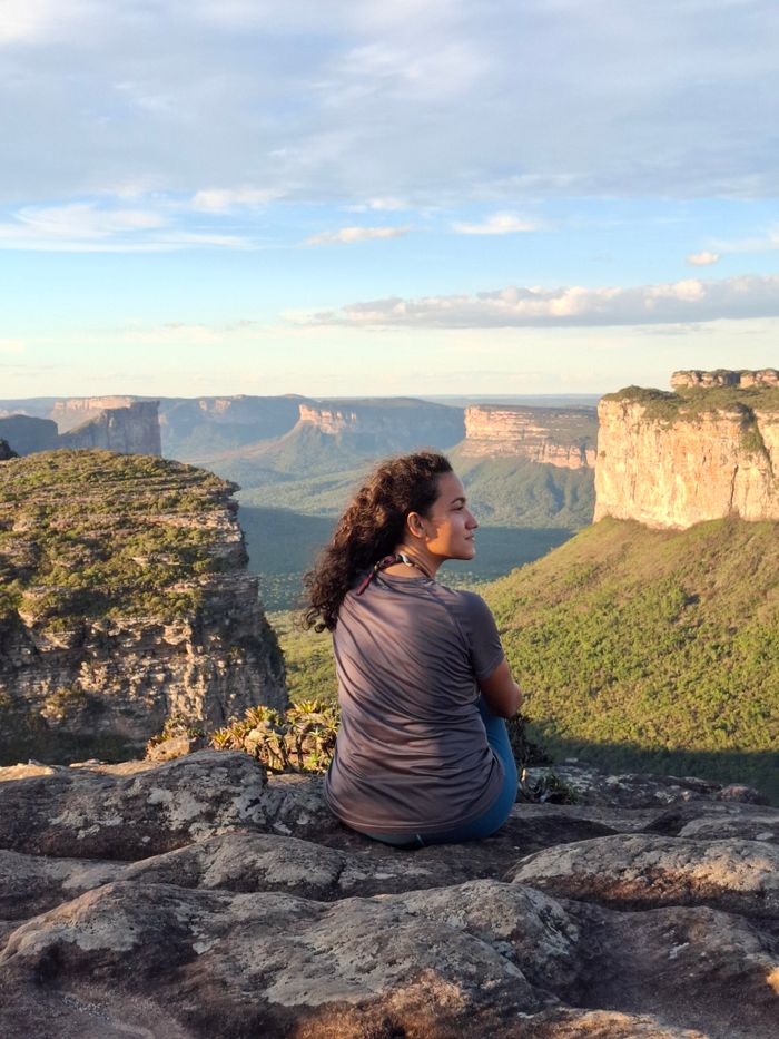 Woman sitting on rock admiring scenic Chapada Diamantina landscape in Bahia, Brazil.